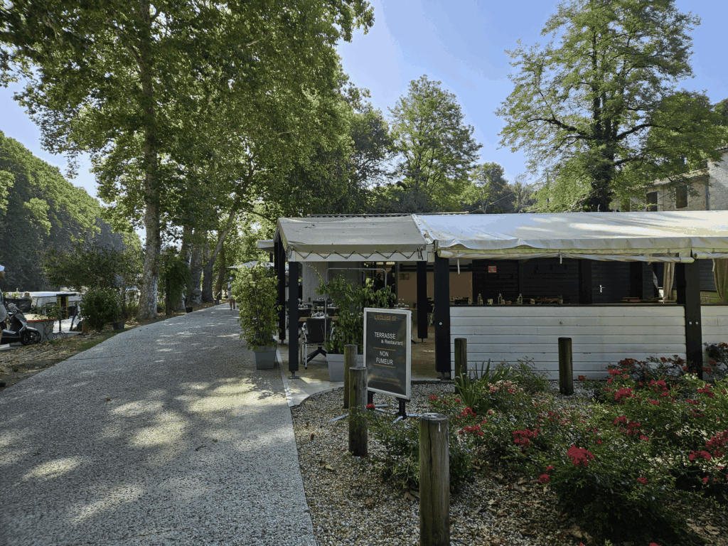 Terrasse couverte du restaurant L'Écluse 52, au bord du chemin de halage, sous les platanes